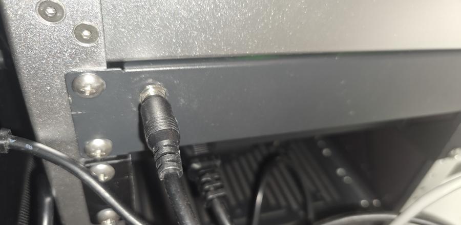 A photo of the rear plate of the rack, showing the power connector for the Turing Pi